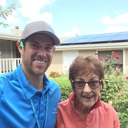 Ben from Burmax Energy with a customer in front of her home's new rooftop solar