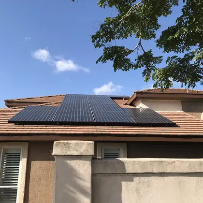 SunPower panels installed on a red tile roof under clear blue sky
