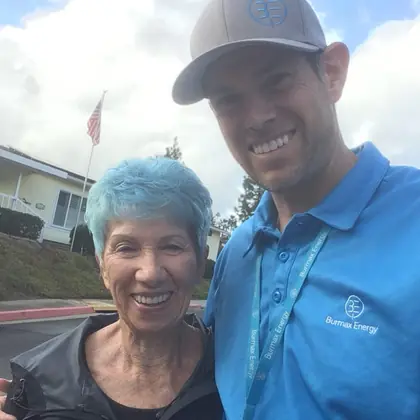 Ben from Burmax Energy with a smiling customer outside her home